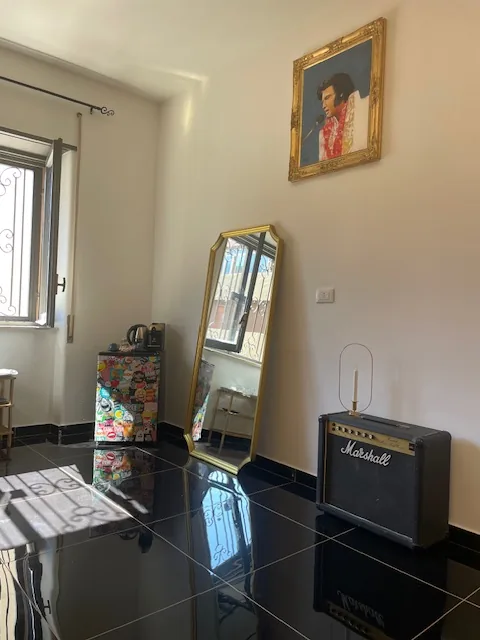 Ritratto di Elvis, specchio dorato e amplificatore Marshall nel monolocale Rock