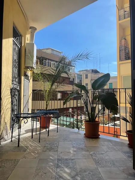 Balcone del bilocale Sicilia affacciato sul cortile interno, con piante e tavolino
